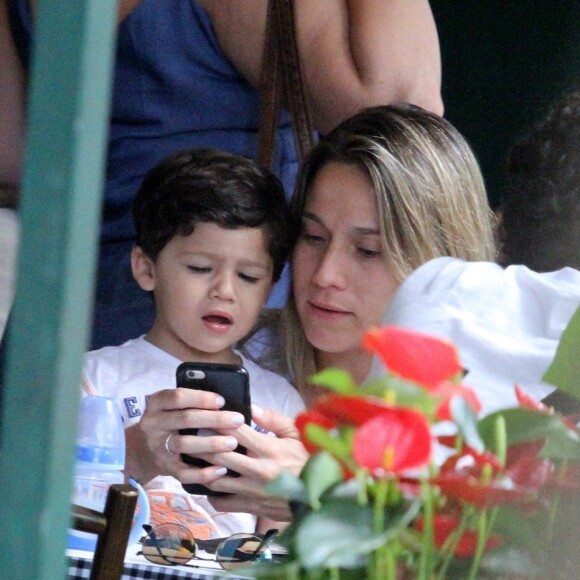 Fernanda Gentil mostra celular para o filho, Gabriel, em restaurante na Gávea