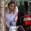Fernanda Gentil arruma a roupa do filho, Gabriel, em restaurante no Rio de Janeiro