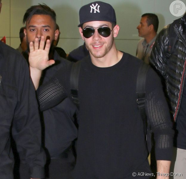 Nick Jonas acena para fãs ao desembarcar no Aeroporto Internacional de Guarulhos, em São Paulo, neste sábado, dia 9 de dezembro de 2017