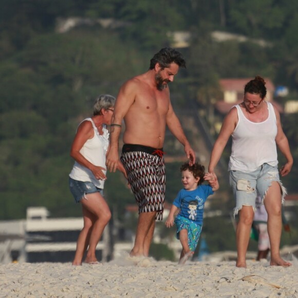 Alexandre Nero caminha pela areia com filho, Noá, de 2 anos