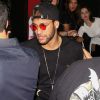 O jogador Neymar exibiu look com boné e óculos de lentes vermelhas ao chegar ao local