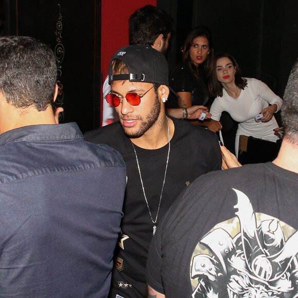 O jogador Neymar exibiu look com boné e óculos de lentes vermelhas ao chegar ao local