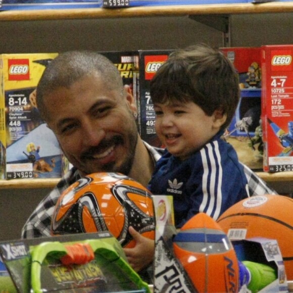 Sorridentes, Fernando Medeiros e o filho, Lucca, escolhem brinquedo em loja no Rio de Janeiro