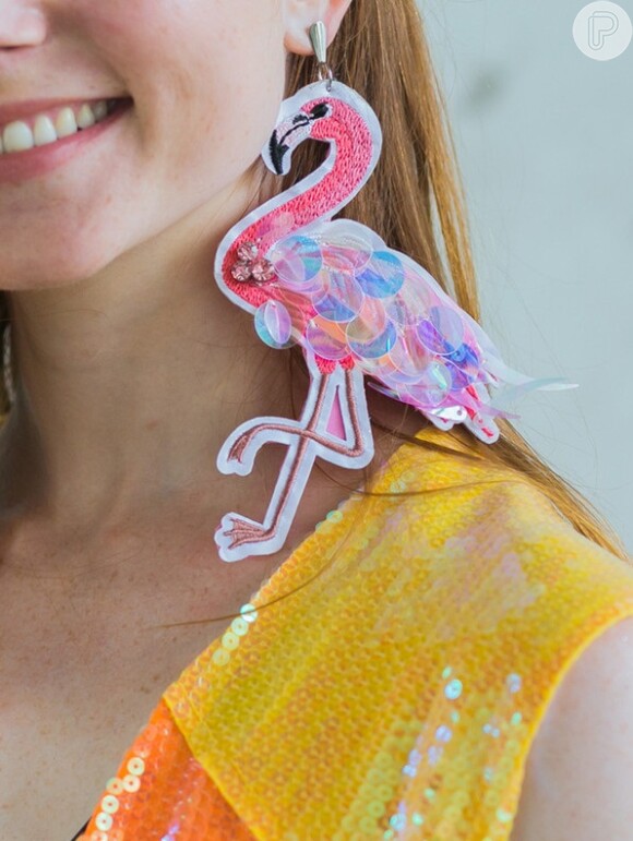 O paetê também está presente no par de brincos de flamingo da Dercy, que custa R$ 88