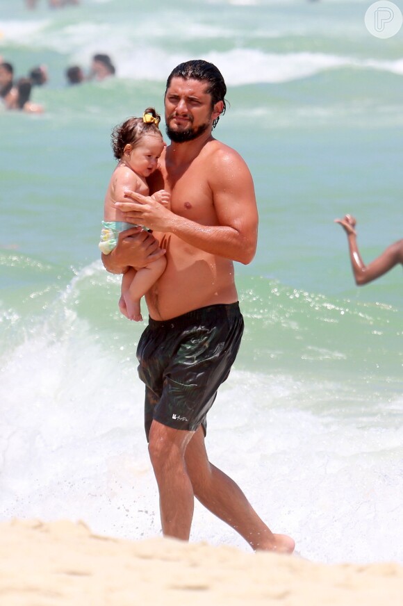 Bruno Gissoni segura Madalena com cuidado ao sair d´água na praia