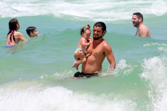 Bruno Gissoni entrou no mar com a filha no colo na praia da Barra da Tijuca