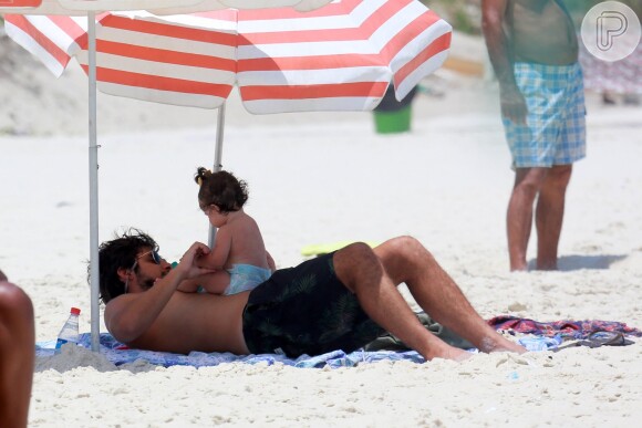 Bruno Gissoni brinca com Madalena no colo durante passeio na praia