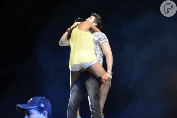 Cantor Luan Santana é agarrado por palco por um fã durante um show na Bahia