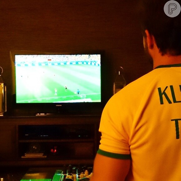 O ator Klebber Toledo compartilhou uma foto diante da TV com uma camisa da Seleção