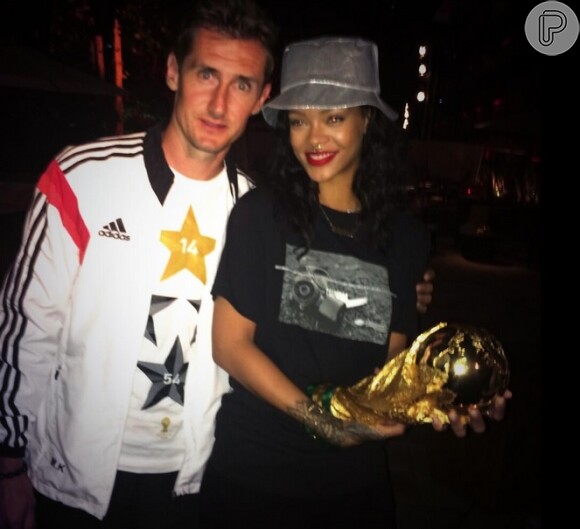 Rihanna segura a taça da Copa do Mundo e comemora vitória alemã ao lado do atacante do time, Klose
