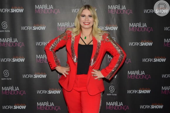 Marília Mendonça usou uma blusa preta justinha sob o blazer vermelho com detalhes metalizados