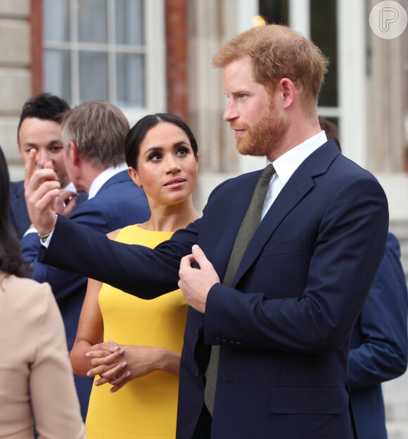 Meghan Markle presta atenção na fala do marido, Príncipe Harry