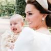 Príncipe Louis foi fotografado sorridente ao lado da mãe, Kate Middleton, em uma nova foto divulgada do batizado do irmão de George e Charlotte
