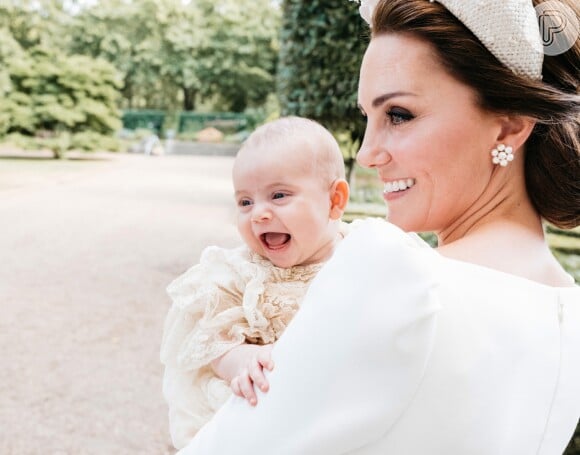 Príncipe Louis foi fotografado sorridente ao lado da mãe, Kate Middleton, em uma nova foto divulgada do batizado do irmão de George e Charlotte
