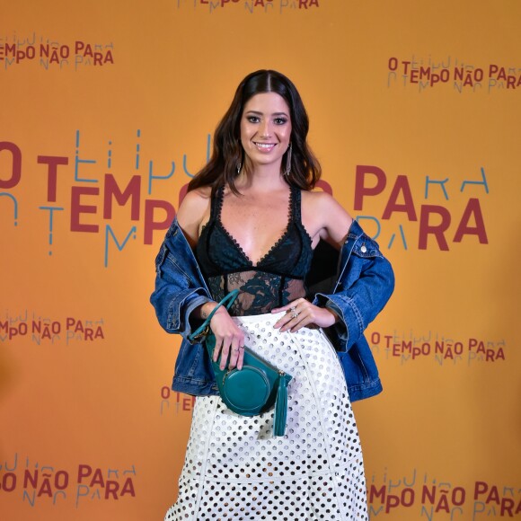 Estilosa, Malu Falangola escolheu top em estilo lingerie com saia vazada branca, que complementou com jaqueta jeans e clutch verde para a festa de lançamento da novela 'O Tempo Não Para', em 16 de julho de 2018