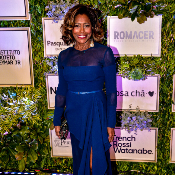 Elegante, Gloria Maria escolheu look azul profundo com leve transparência nos ombros e o complementou com maxibrincos