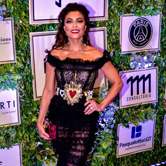 O look Dolce & Gabbana, todo transparente bem barroco de Juliana Paes, com cinto marcando a cintura e clutch vermelha