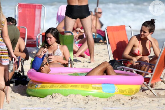 Deitado em uma piscina de plástico, Marcello Melo Jr. relaxou enquanto se bronzeou no sol