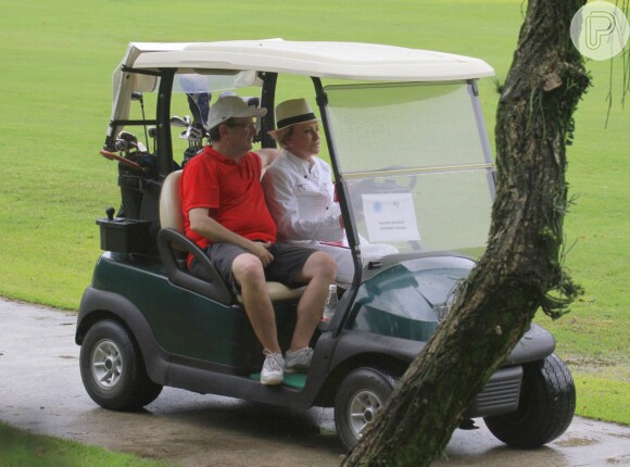 Ana Maria Braga e Mauro Bayout andando em um carrinho de golfe