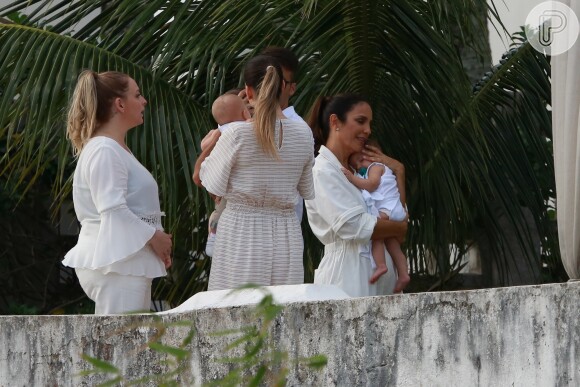 Ivete Sangalo posa abraçada à filha gêmea, em batizado