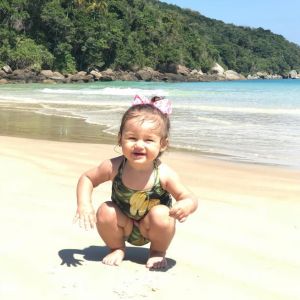 Madalena, filha de Bruno Gissoni e Yanna Lavigne, se divertiu na areia com maiô tropical