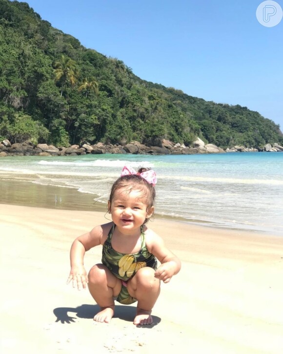 Madalena, filha de Bruno Gissoni e Yanna Lavigne, se divertiu na areia com maiô tropical