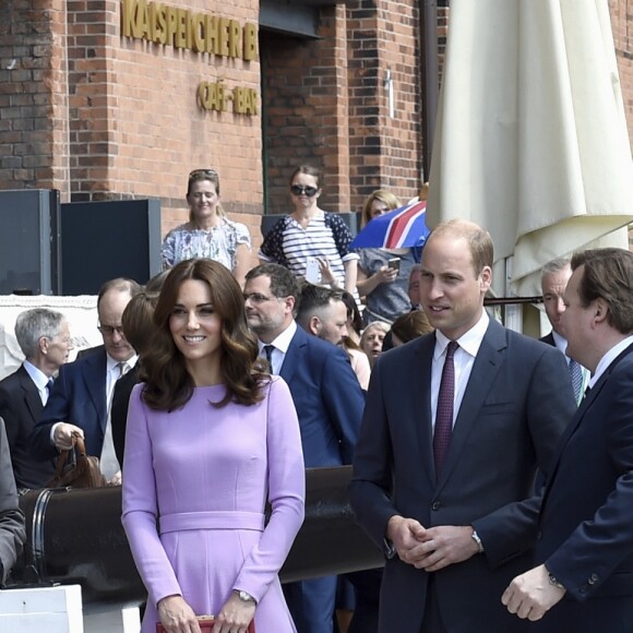 Na Alemanha, Kate Middleton escolheu uma clutch vermelha em pele de serpente de Anya Hindmarch