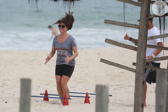 Giovanna Antonelli sua a camisa durante treino funcional em praia do Rio de Janeiro