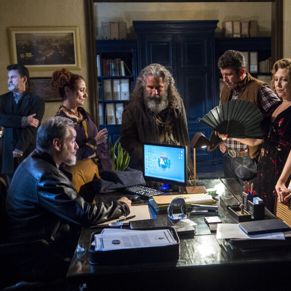 Os guardiões Milu (Zezé Polessa), Egídio (Antonio Calloni), Eurico (Dan Stulbach), Ondina (Ana Beatriz Nogueira), Machado (Milhem Cortaz), Aranha (Paulo Rocha) e Feliciano (Leopoldo Pacheco) discutem sobre o sumiço de Leon e especulam sobre quem será o novo guardião-mor, na novela 'O Sétimo Guardião'