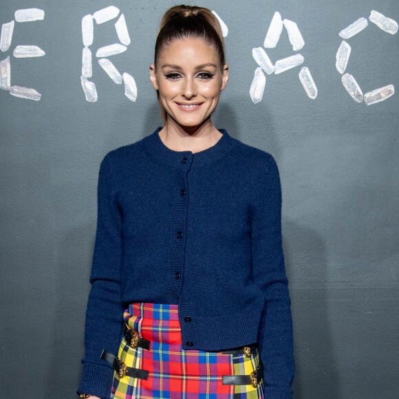Olivia Palermo combinou um suéter azul marinho com saia midi de lã com estampa quadriculada tartã de £1,630, aproximadamente R$ 8 mil