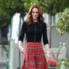 Kate Middleton combinou a saia xadrez midi e plissada com botas e cardigã preto