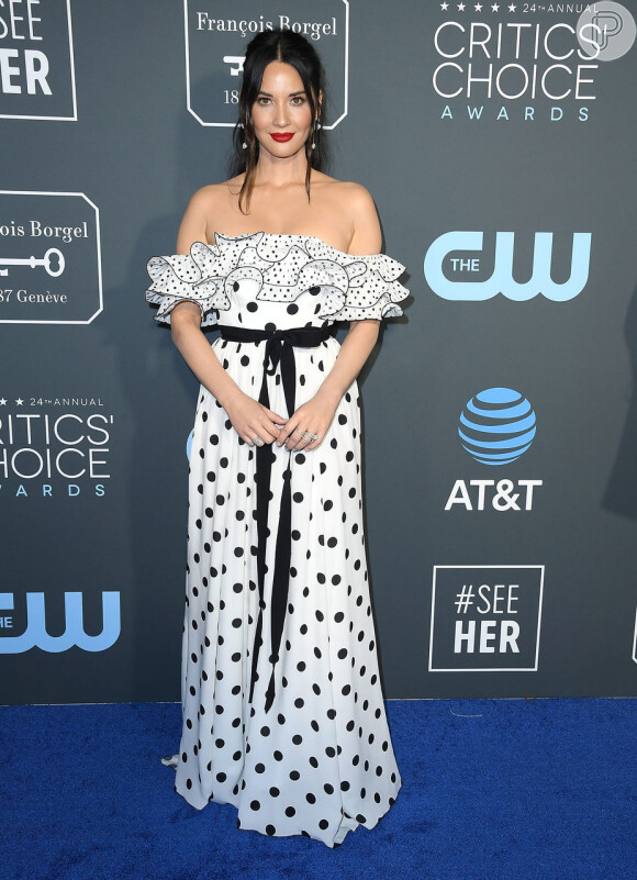 Olivia Munn escolheu um tomara que caia com babados e poá da grife Carolina Herrera para o Critics' Choice Awards 2019