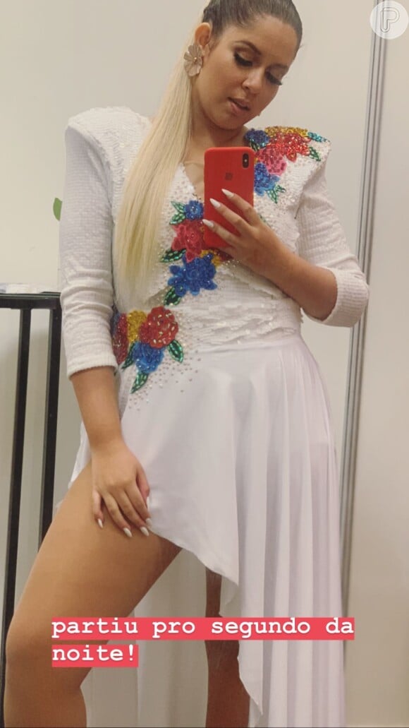 Marília Mendonça usou blusa com detalhes florais e ombreira, além de uma saia assimétrica