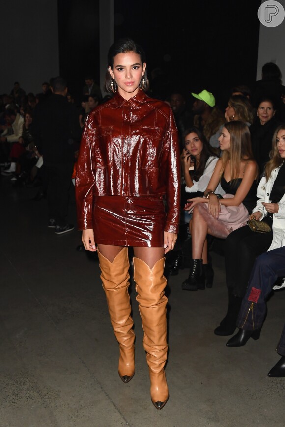 Bruna Marquezine usou jaqueta e minissaia de vinil com botas plásticas brilhantes no desfile da marca John John, na Semana de Moda de Nova York, na noite desta terça-feira (12)