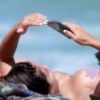 Anitta dispensou a parte de cima do biquíni ao curtir dia de praia com amigos