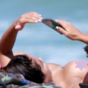 Anitta dispensou a parte de cima do biquíni ao curtir dia de praia com amigos