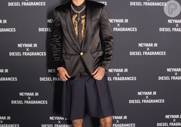 Neymar exibe look com camisa preta com bordados em dourado, blazer e uma bermuda saia