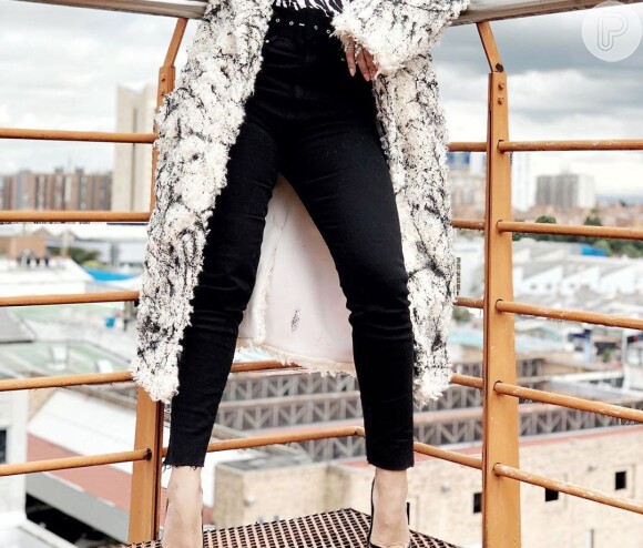 Anitta usa calça skinny preta com a barra desfiada em look de frio durante viagem nesta quarta-feira, dia 10 de julho de 2019