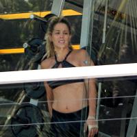 Danielle Winits malha de top e exibe barriga sarada em academia do Rio