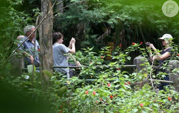 Harrison Ford observa a natureza enquanto Calista Flockhart e Liam tiram fotos