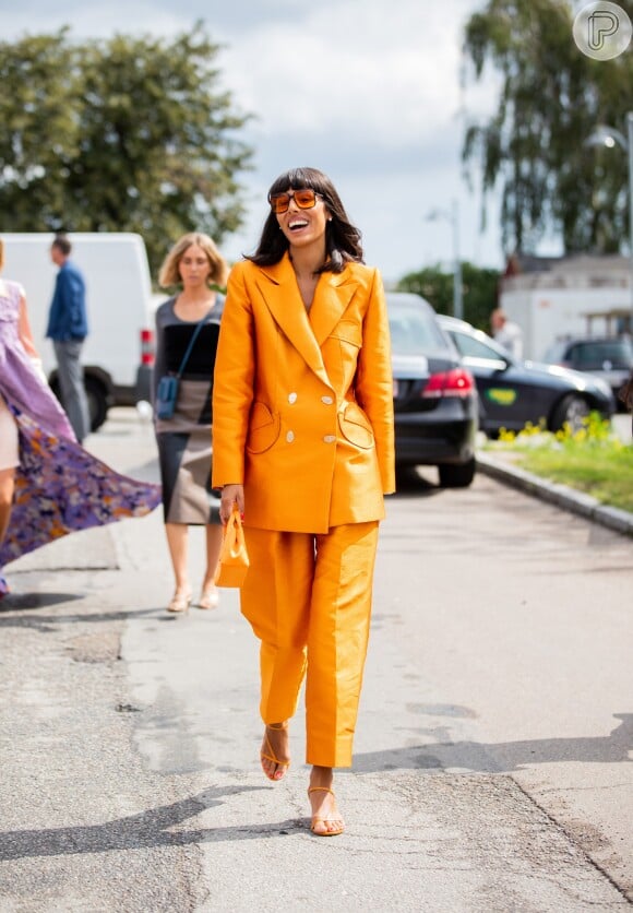 Que tal o look total com direito a terno oversized, bolsa de mão, sandália de salto e óculos, TUDO laranja