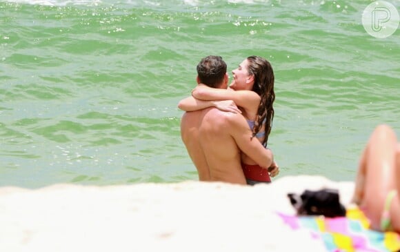 Cauã Reymond e Mariana Goldfarb trocam carinhos em praia da Barra da Tijuca