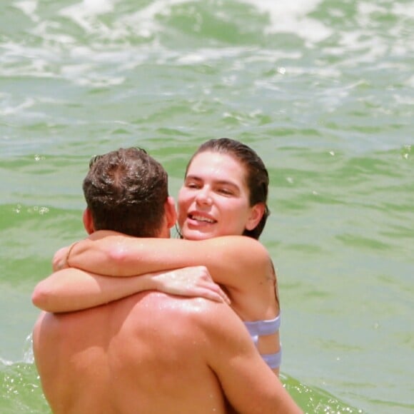 Cauã Reymond e Mariana Goldfarb se abraçam ao tomar banho de mar