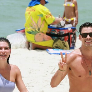 Cauã Reymond e Mariana Goldfarb acenam para fotógrafo ao deixar praia