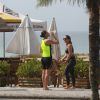 Débora Nascimento se refresca com uma garrafinha de água após correr na praia da Barra da Tijuca