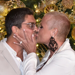 Xuxa deixou sutiã à mostra em look com decote e fenda e beijou o namorado, Junno Andrade, em jantar beneficente nesta segunda-feira, 16 de dezembro de 2019