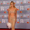 A cantora Ashley Roberts escolheu look nude com barriga de fora e bolsa de pluma no BRIT Awards