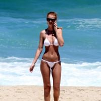 De biquíni branco, Cintia Dicker se bronzeia e exibe corpão em praia do Rio