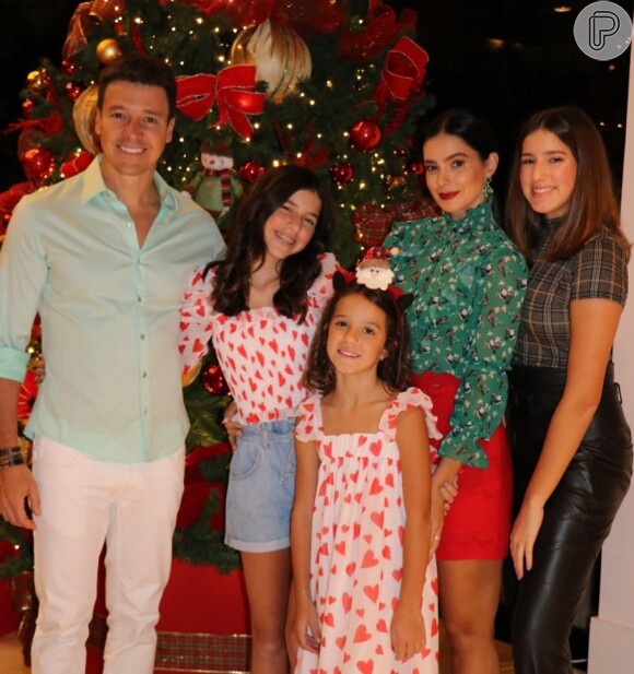 Vera Viel comemora Natal em família com blusa estampada de gola alta e bermuda vermelha