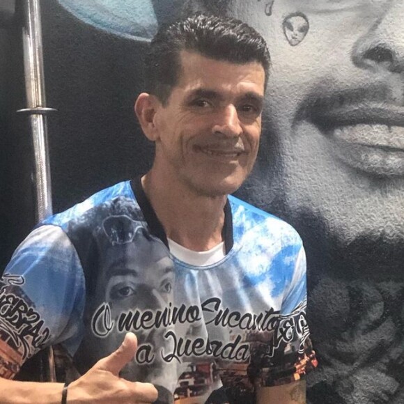 Pai de MC Kevin ao lado de grafite em homenagem ao filho
